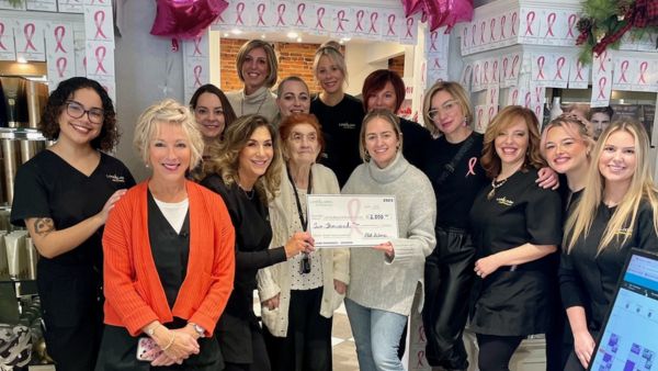 A group of women, smiling and holding up a check for $2,000.