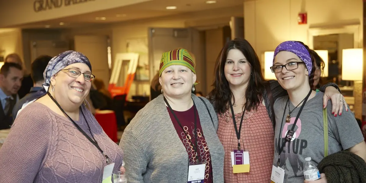 Four white women, three in headscarves, attend the conference