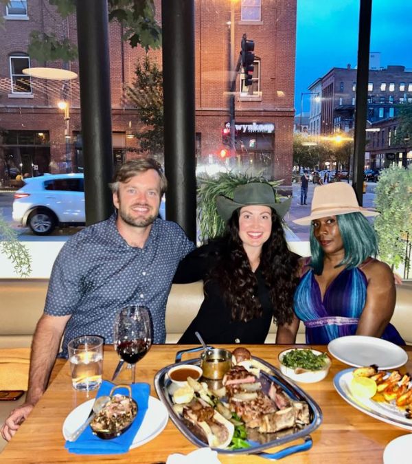 Camille Lewis celebrates her 50th birthday with her caregivers at a restaurant. A huge spread in front of them at the table.