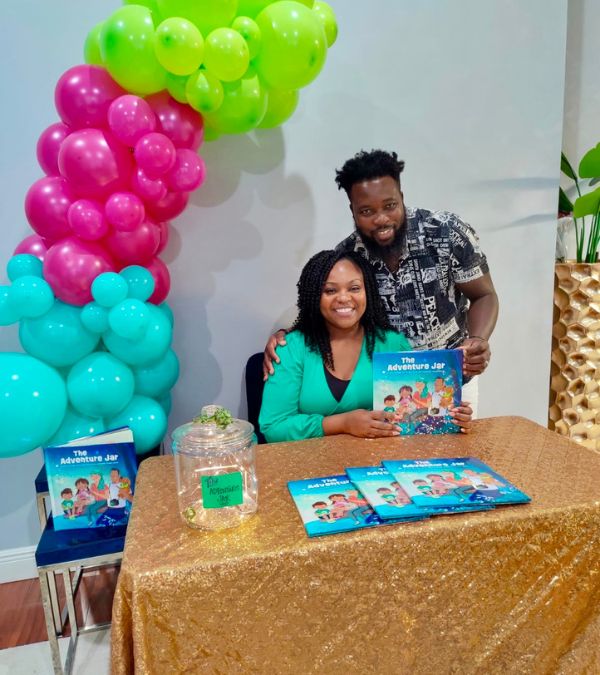 Jonise Louis and her husband at a breast cancer event table.