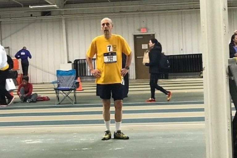 Bruce Rubin stands in an indoor basketball court, waiting for his turn to shoot.